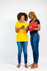 young black beautiful ladies going through something on a smartphone and taking note on a notepad