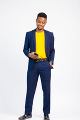 young black handsome man, wearing a suit, smiling while using his smartphone