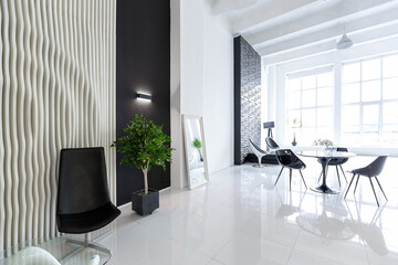 Luxurious futuristic trendy modern interior in contrasting black and white colors with interesting fashionable black furniture and decorated wall