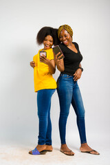 Fototapeta premium young black beautiful ladies jubilating over something they received on their smartphones