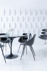 Luxurious futuristic trendy modern interior in contrasting black and white colors with interesting fashionable black furniture and decorated wall