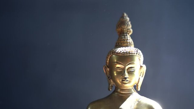golden Idol face of buddha mediating with dark background