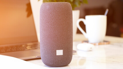 A portable speaker with built-in smart intelligence. Musical column. Marble table, work atmosphere,...