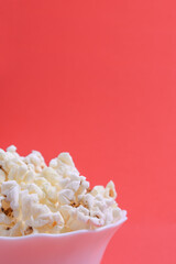 Popcorn in bowl on a red background. Close up. Front view