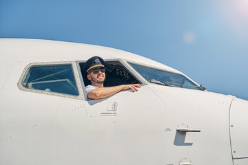Fototapeta na wymiar Young airman in sunglasses posing for the camera