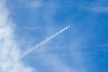 condensation trail of a plane in the blue sky