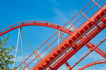 Roller coaster in an amusement park on a blue sky background on a sunny summer day