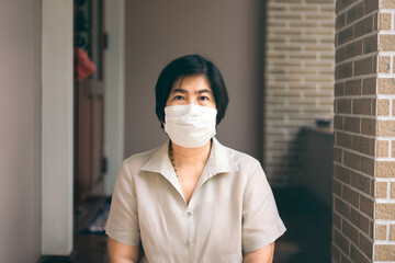 Portrait of asian elder woman wearing face mask at home