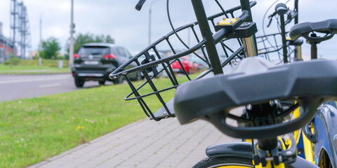 bicycle seat and basket of black colour against paved street