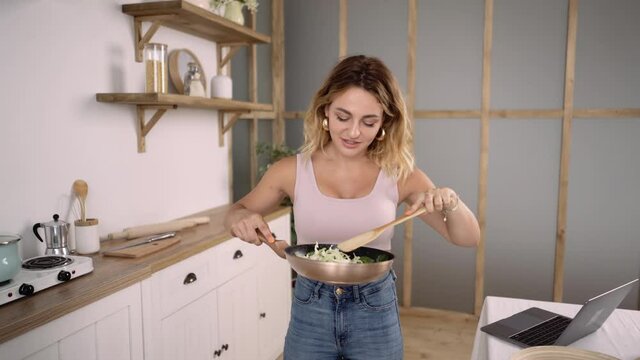 Close up of Young Fit Girl Cooking Healthy Tasty Food in a Cozy Kitchen. Woman Recording Video Recipy or Cooking Lesson at Home. Girl Having Positive Cooking Experience.