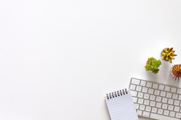 White desk at home seen from above. Keyboard, notebook and succulents. Office space. Home office....