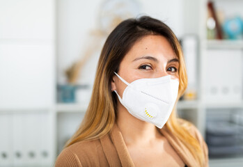 Portrait of businesswoman in disposable face mask in business office, new normal due to coronavirus...