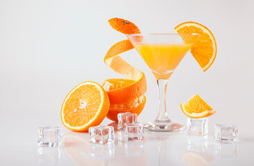 Martini glasses of orange juice and ice cube on white background. Still life for cafe and bar.