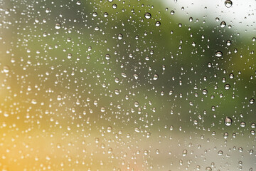 Raindrops on window glasses surface with road background .