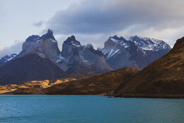 Peaceful landscape of large lake at the foot of the mountain with snow on the mountains peak in Patagonia, Chile.