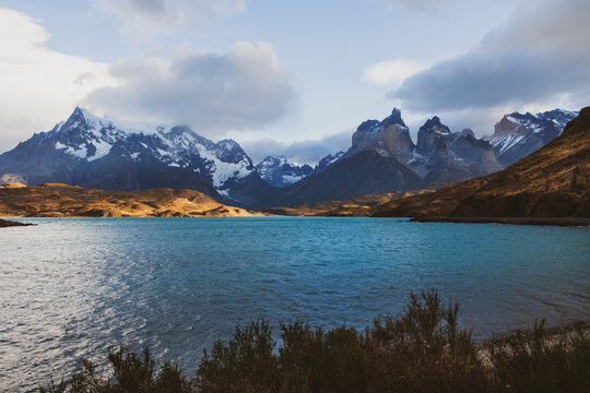 Peaceful landscape of large lake at the foot of the mountain with snow on the mountains peak in Patagonia, Chile.