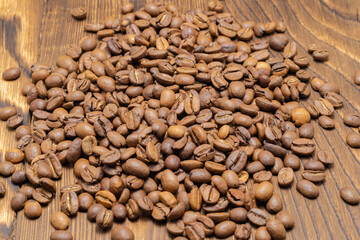 coffee beans scattered on a wooden background. close-up