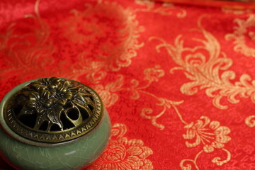 still life in Chinese style. incense burner and fan isolated on red background