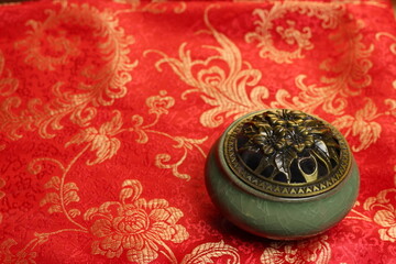 still life in Chinese style. incense burner and fan isolated on red background