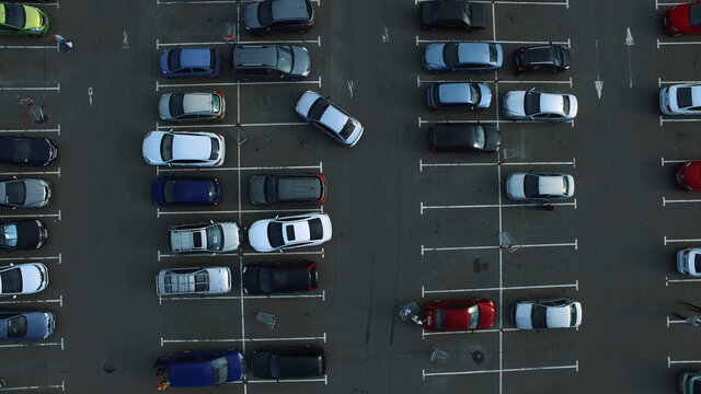 Drone footage cars parking at congested parking lots. people walking parking