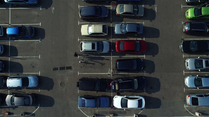 Birds eye view cars moving at parking. Drone filming congested parking lot