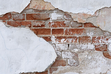 Background. A fragment of a brick building with flaking plaster.