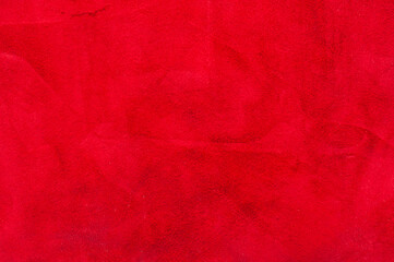 red matte background of suede fabric, closeup. Velvet texture of seamless wine leather. Felt material macro