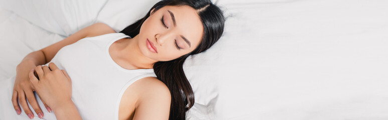 Naklejka premium Panoramic shot of asian woman sleeping on white bedding at morning