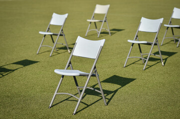 Chairs on the turf of a soccer field maintaining the social distance imposed by corona virus restrictions during an event
