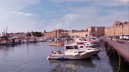 Fototapeta na wymiar Rhodes, embankment and boats in Mandraki harbour, Rhodes, Greece