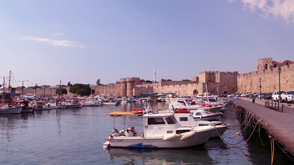 Fototapeta na wymiar Rhodes, embankment and boats in Mandraki harbour, Rhodes, Greece
