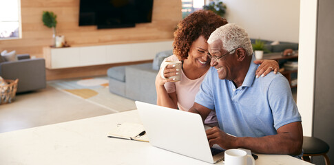 Senior African American Couple Using Laptop To Check Finances At Home - Powered by Adobe