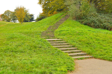 steps going uphill among green meadows in a park