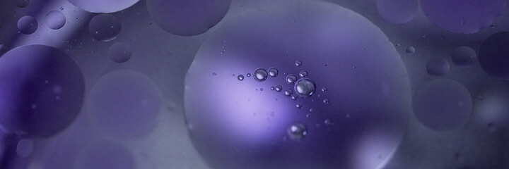 Blue oil bubbles of various size in the water. Calm and mystic. Banner size