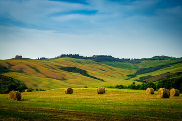 Farmland with hay rolls and farmhouses in Tuscany Italy