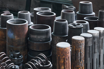 industrial background - rusty hardware, parts of turbodrills of various diameters are in the...