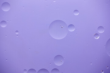 Current collection of brilliant backgrounds for your design. Close-up shot of water circles and drops on violet paint with swirls.