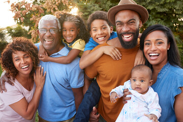 Portrait Of Multi-Generation African American Family Relaxing In Garden At Home Together - Powered by Adobe