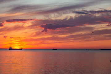 Silhouette of ships on background out at sea at beautiful sunset