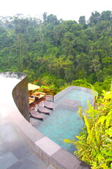 Beautiful turquoise blue green water of an hanging swimming pool with garden at Ubud, Bali, Indonesia.