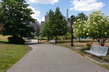 Fototapeta premium Empty Walkway with Green Trees and Grass at Southpoint Park on Roosevelt Island during Summer in New York City