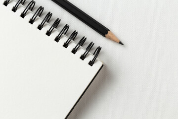 Top view, empty notebook and pencil on a white background.