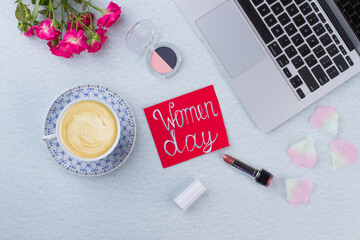 Fototapeta na wymiar Flat lay women day concept and cup of coffee. Laptop with flowers and cup of coffee on a white table.