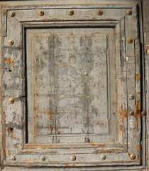 
Wood panel covered with gray paint with rusty old nail heads