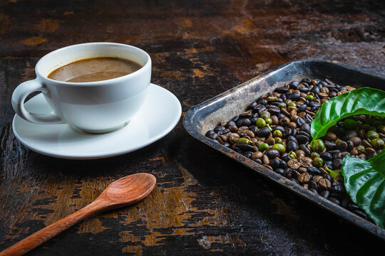 A cup of coffee and coffee beans on a wooden table