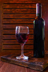 .Wine glass and wine bottle on the wooden table