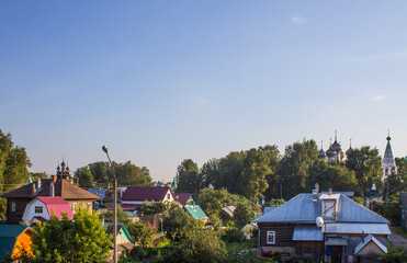 Fototapeta na wymiar Panoramic view of the city of Kostroma Russia with old wooden houses and temples among green trees against a blue sky and copy space