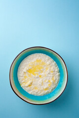Portion hot of rice porridge in bowl on blue background