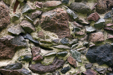 Stone wall of rough unprocessed stones. Part of old castle stone wall, for background or texture.