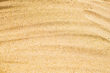 Beautiful beige sandy background. Sand close up. Vacation and travel concept.